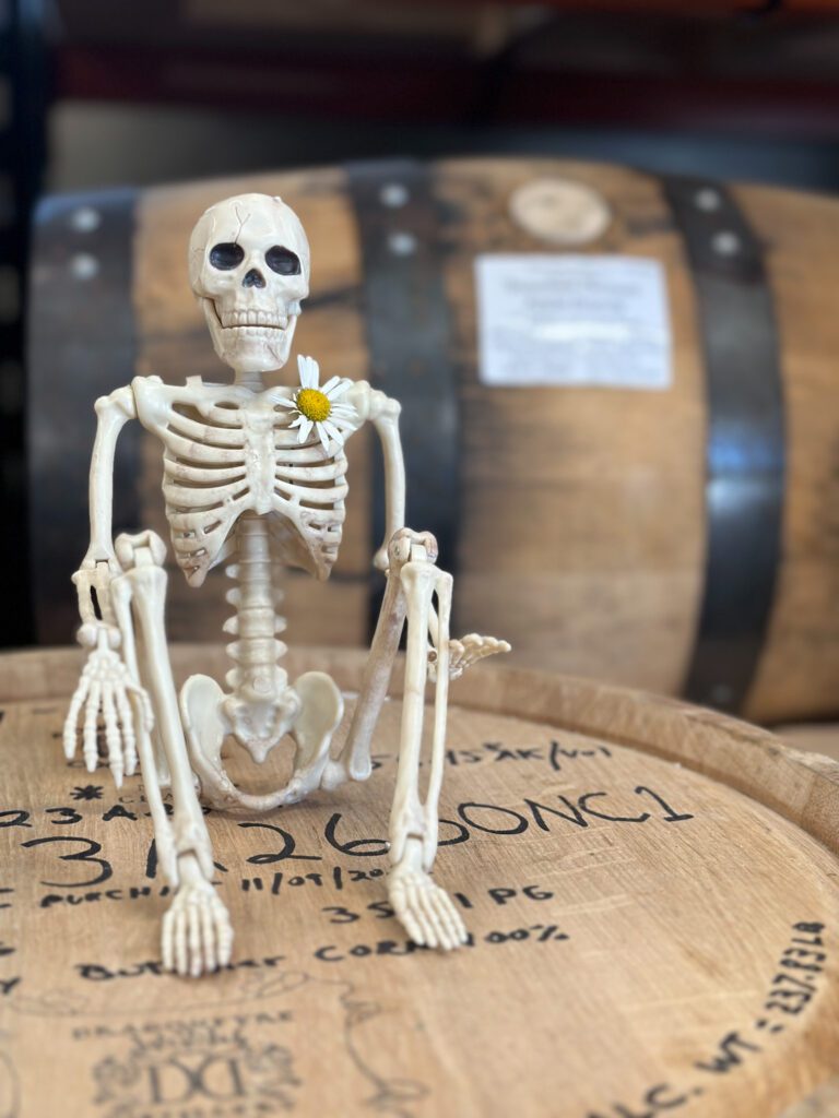 skeleton sitting on whiskey barrel