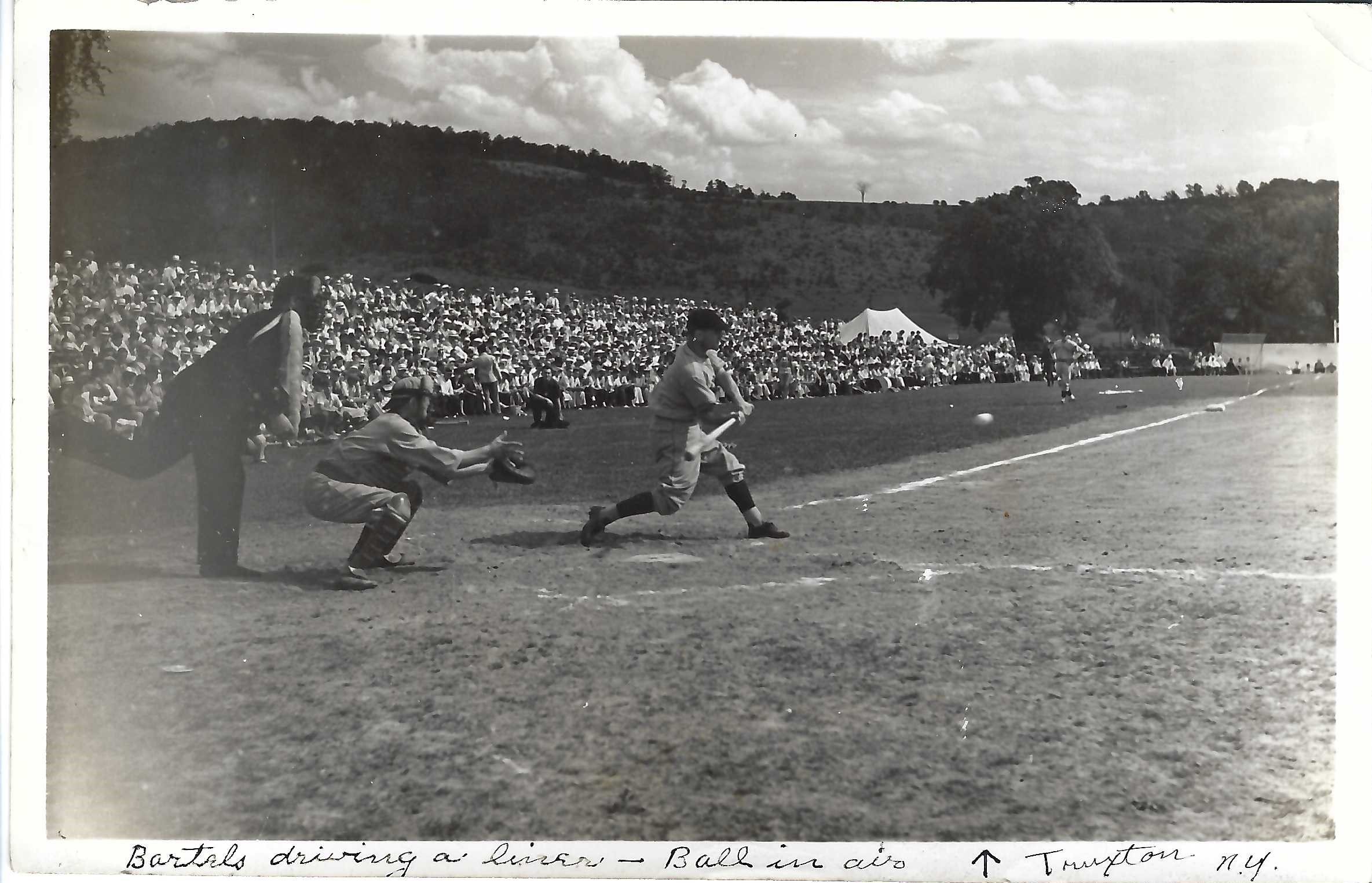 black and white photo of historic baseball game. batter swinging bat.