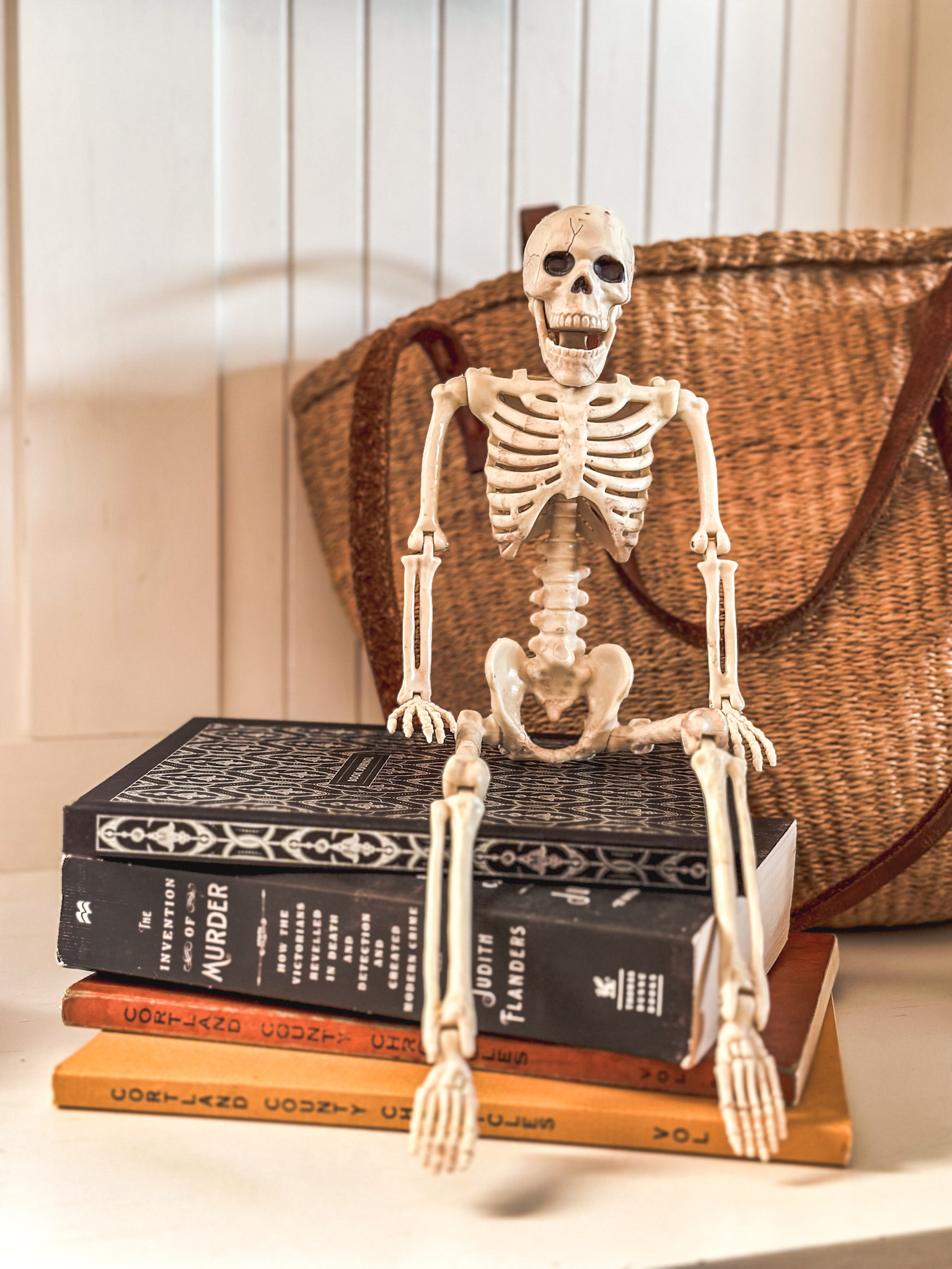 skeleton sitting on pile of books